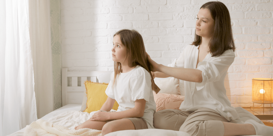 A mother combing hair of a daughter